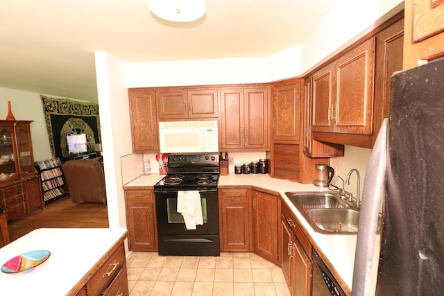 1713 Boca Raton Blvd, Kokomo, IN 46902 - kitchen with black appliances, a sink, brown cabinets, light tile patterned floors, and light countertops