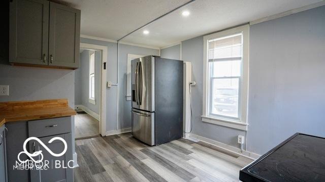 352 W 28th St, Indianapolis, IN 46208 - kitchen featuring stainless steel fridge, wooden counters, light wood-style flooring, gray cabinets, and plenty of natural light