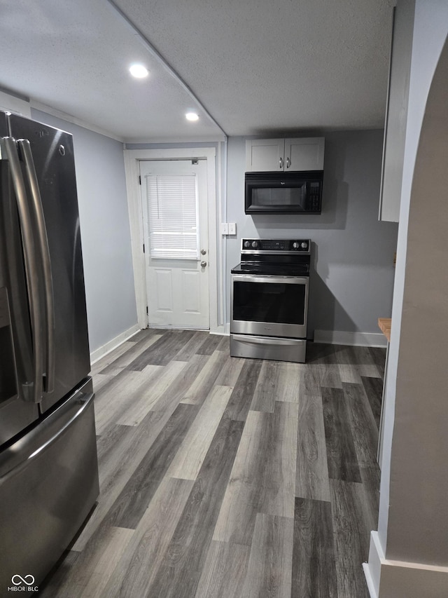 352 W 28th St, Indianapolis, IN 46208 - kitchen with stainless steel appliances, recessed lighting, a textured ceiling, wood finished floors, and baseboards