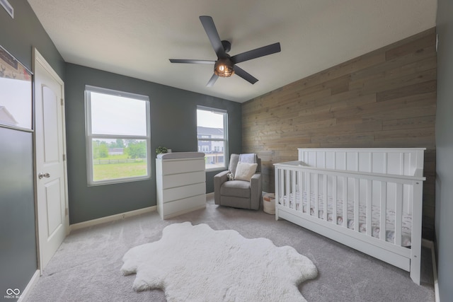 640 Axford Bay Dr, Westfield, IN 46074 - bedroom featuring carpet, wooden walls, a crib, a ceiling fan, and baseboards