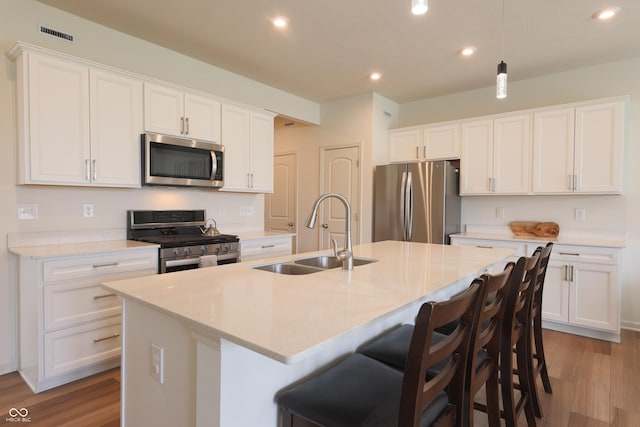 640 Axford Bay Dr, Westfield, IN 46074 - kitchen with appliances with stainless steel finishes, a sink, an island with sink, recessed lighting, and wood finished floors