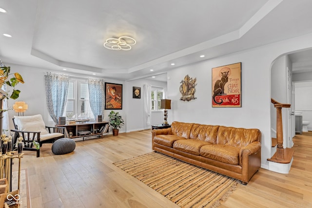 1618 Villa Ave, Indianapolis, IN 46203 - living area featuring a tray ceiling, arched walkways, light wood finished floors, recessed lighting, and baseboards