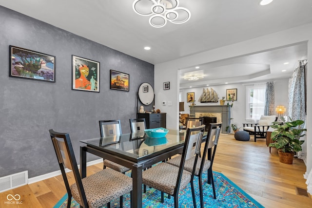 1618 Villa Ave, Indianapolis, IN 46203 - dining space featuring light wood finished floors, a fireplace, a chandelier, and recessed lighting