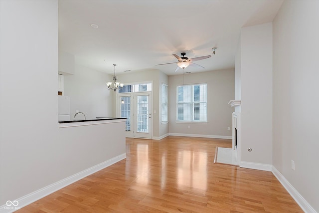 355 E Ohio St Unit 209, Indianapolis, IN 46204 - unfurnished living room with a chandelier, ceiling fan, light wood finished floors, a fireplace with flush hearth, and baseboards