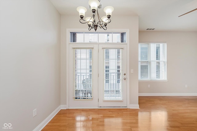 355 E Ohio St Unit 209, Indianapolis, IN 46204 - foyer entrance featuring a chandelier, light wood-style flooring, healthy amount of natural light, and baseboards