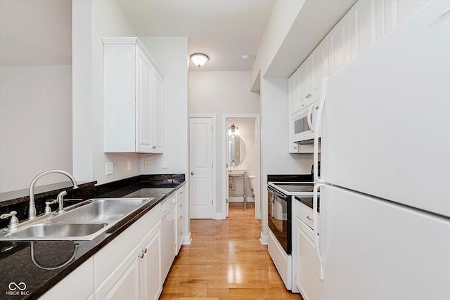 355 E Ohio St Unit 209, Indianapolis, IN 46204 - kitchen featuring white appliances, a sink, white cabinetry, light wood-style floors, and dark countertops