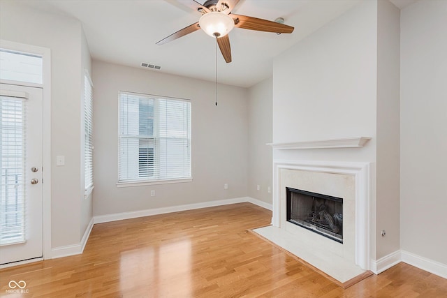 355 E Ohio St Unit 209, Indianapolis, IN 46204 - unfurnished living room with light wood finished floors, a fireplace, ceiling fan, and baseboards