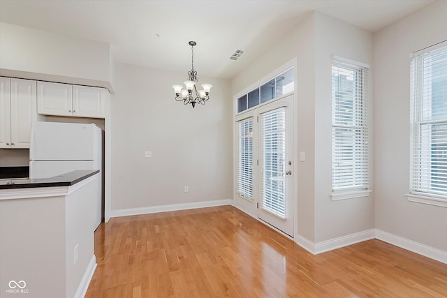 355 E Ohio St Unit 209, Indianapolis, IN 46204 - unfurnished dining area with a chandelier, light wood-style flooring, and plenty of natural light