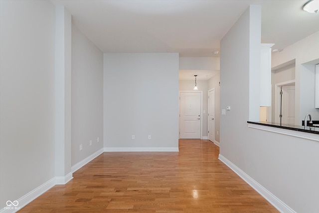 355 E Ohio St Unit 209, Indianapolis, IN 46204 - hall featuring light wood-style flooring, a sink, and baseboards