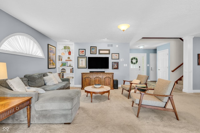103 Gettysburg, Coatesville, IN 46121 - living room featuring stairway, built in features, decorative columns, a textured ceiling, and light colored carpet