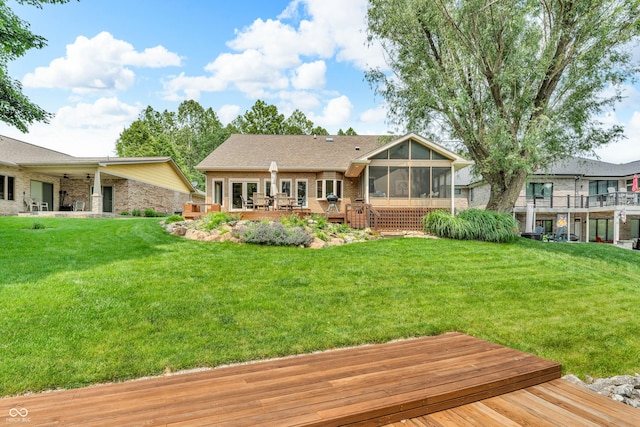 103 Gettysburg, Coatesville, IN 46121 - back of property with a sunroom, a deck, a yard, and brick siding