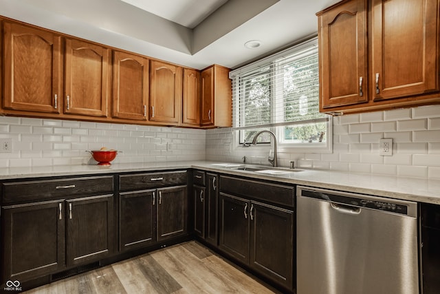 4428 Edinburgh Pt, Indianapolis, IN 46228 - kitchen with stainless steel dishwasher, a sink, light wood-style floors, light stone countertops, and decorative backsplash