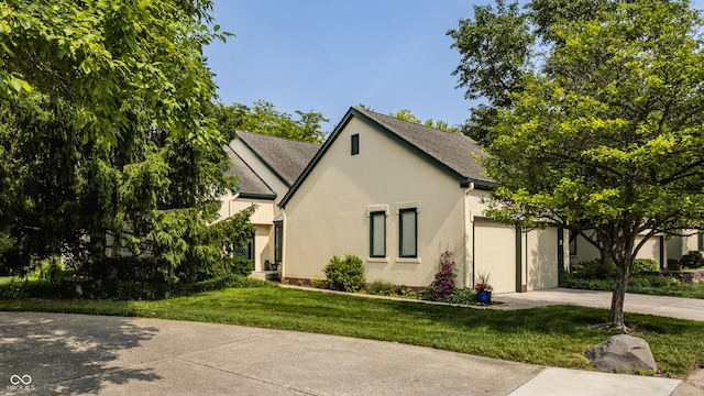 4428 Edinburgh Pt, Indianapolis, IN 46228 - view of front of house with driveway, stucco siding, an attached garage, a front yard, and roof with shingles