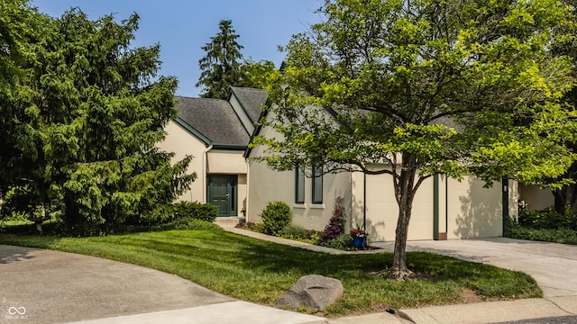 4428 Edinburgh Pt, Indianapolis, IN 46228 - view of property hidden behind natural elements with concrete driveway, stucco siding, a front yard, and a garage