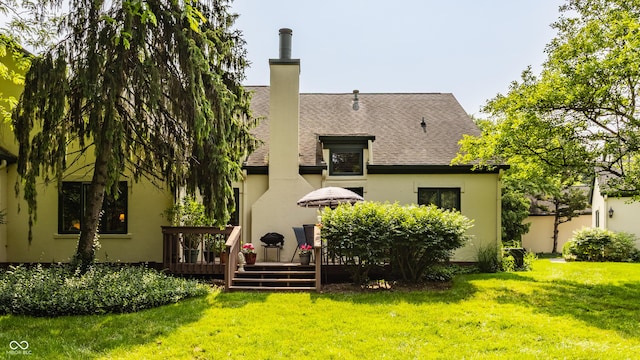 4428 Edinburgh Pt, Indianapolis, IN 46228 - back of property featuring a deck, a lawn, a shingled roof, stucco siding, and a chimney