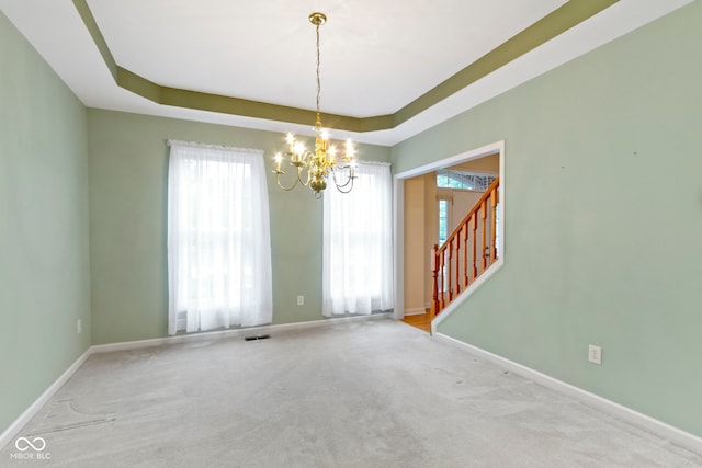 11036 Ravenna Way, Indianapolis, IN 46236 - spare room featuring a chandelier, baseboards, carpet flooring, stairway, and a raised ceiling
