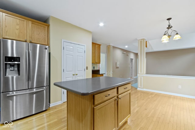 11036 Ravenna Way, Indianapolis, IN 46236 - kitchen featuring stainless steel fridge with ice dispenser, light wood-style floors, a kitchen island, dark countertops, and hanging light fixtures