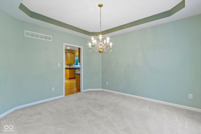 11036 Ravenna Way, Indianapolis, IN 46236 - spare room with a chandelier, light colored carpet, a tray ceiling, and baseboards