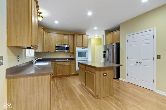 11036 Ravenna Way, Indianapolis, IN 46236 - kitchen with appliances with stainless steel finishes, a sink, light wood-style floors, a kitchen island, and recessed lighting