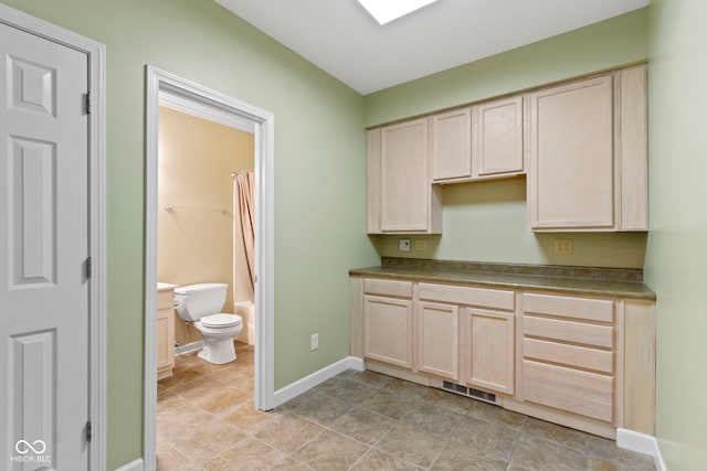 11036 Ravenna Way, Indianapolis, IN 46236 - kitchen featuring light brown cabinetry, baseboards, and dark countertops