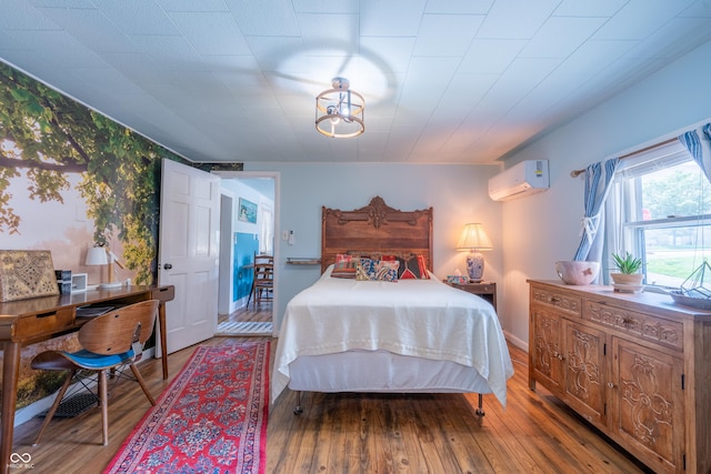 1101 S Rogers St, Bloomington, IN 47403 - bedroom with a wall unit AC and hardwood / wood-style floors