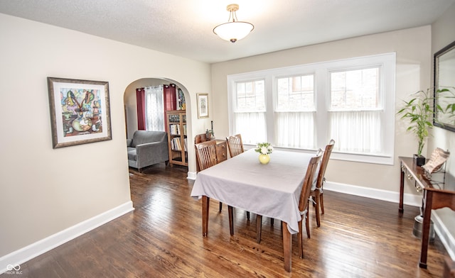 5024 N Kenwood Ave, Indianapolis, IN 46208 - dining space with arched walkways, dark wood-type flooring, and baseboards