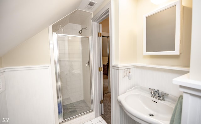 5024 N Kenwood Ave, Indianapolis, IN 46208 - bathroom featuring a shower stall, a sink, a wainscoted wall, lofted ceiling, and tile patterned floors