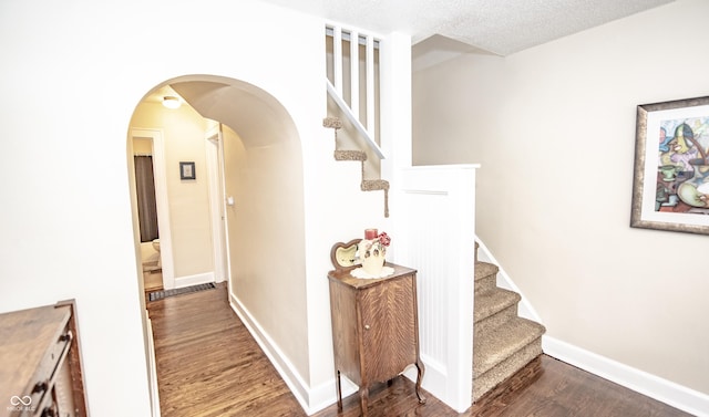 5024 N Kenwood Ave, Indianapolis, IN 46208 - corridor with wood finished floors, stairway, arched walkways, baseboards, and a textured ceiling