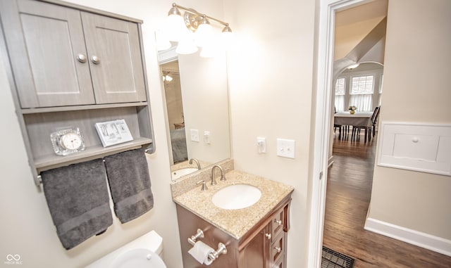 5024 N Kenwood Ave, Indianapolis, IN 46208 - half bathroom with wood finished floors, vanity, toilet, and baseboards
