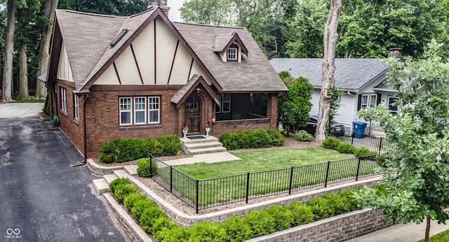 5024 N Kenwood Ave, Indianapolis, IN 46208 - tudor house with brick siding, stucco siding, a chimney, and driveway