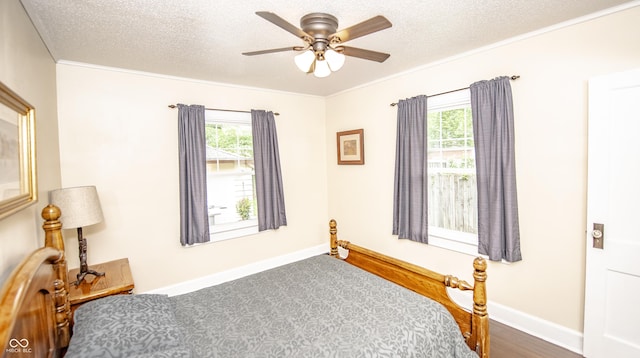 5024 N Kenwood Ave, Indianapolis, IN 46208 - bedroom with multiple windows, a textured ceiling, crown molding, dark wood-type flooring, and baseboards