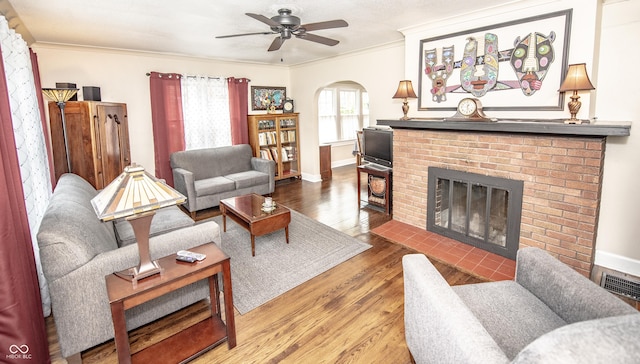 5024 N Kenwood Ave, Indianapolis, IN 46208 - living area featuring a fireplace, arched walkways, ornamental molding, wood finished floors, and a ceiling fan
