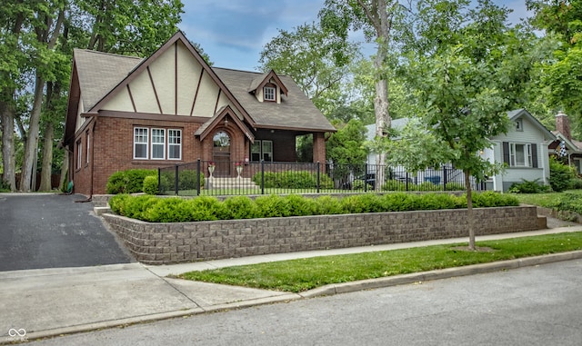 5024 N Kenwood Ave, Indianapolis, IN 46208 - tudor home with brick siding, a fenced front yard, stucco siding, and driveway
