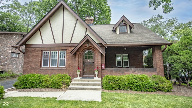 5024 N Kenwood Ave, Indianapolis, IN 46208 - tudor-style house with a chimney, stucco siding, brick siding, and a shingled roof