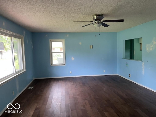 8045 Briarwood Dr, Indianapolis, IN 46227 - empty room with a textured ceiling, healthy amount of natural light, dark wood-style flooring, a ceiling fan, and baseboards