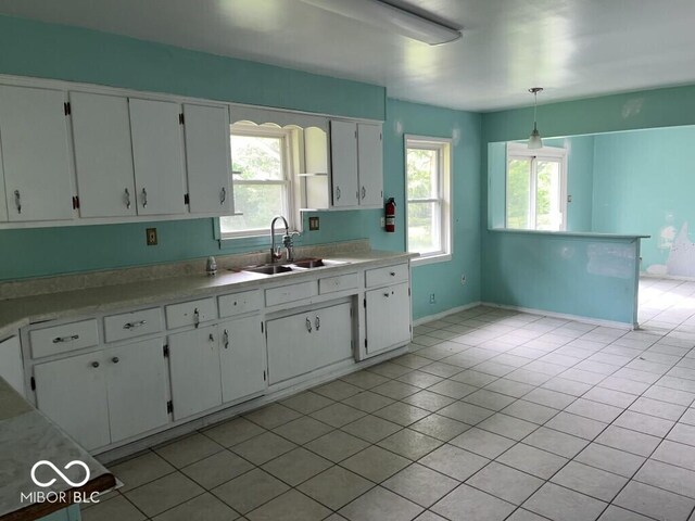 8045 Briarwood Dr, Indianapolis, IN 46227 - kitchen with white cabinets, light countertops, a sink, and healthy amount of natural light