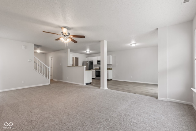 2270 Collins Way, Greenfield, IN 46140 - unfurnished living room with light colored carpet, ceiling fan, stairway, and a textured ceiling