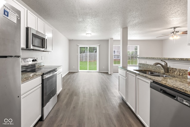 2270 Collins Way, Greenfield, IN 46140 - kitchen featuring appliances with stainless steel finishes, dark wood finished floors, white cabinets, light stone counters, and a textured ceiling