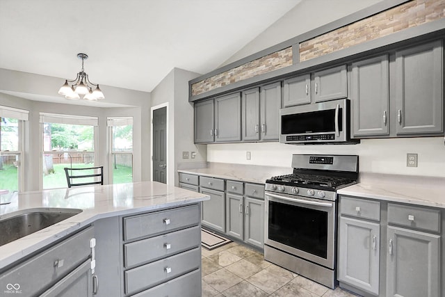 1264 Black Oak Dr, Greenwood, IN 46143 - kitchen featuring appliances with stainless steel finishes, gray cabinets, vaulted ceiling, a chandelier, and light stone countertops