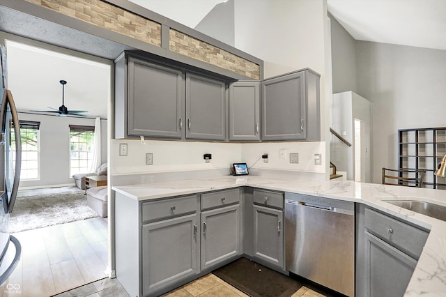 1264 Black Oak Dr, Greenwood, IN 46143 - kitchen featuring stainless steel dishwasher, gray cabinets, ceiling fan, light stone countertops, and high vaulted ceiling