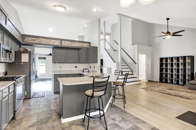 1264 Black Oak Dr, Greenwood, IN 46143 - kitchen with appliances with stainless steel finishes, a sink, high vaulted ceiling, a ceiling fan, and gray cabinets