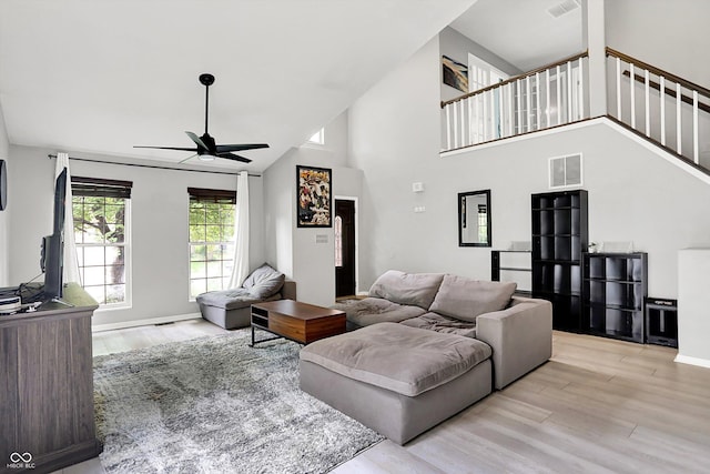 1264 Black Oak Dr, Greenwood, IN 46143 - living room featuring ceiling fan, wood finished floors, high vaulted ceiling, stairs, and baseboards