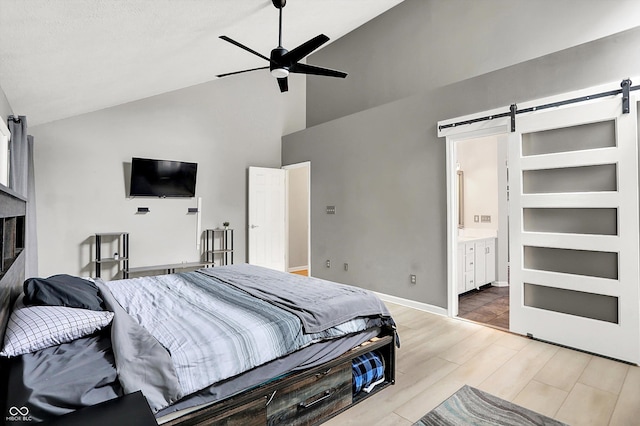1264 Black Oak Dr, Greenwood, IN 46143 - bedroom with a barn door, high vaulted ceiling, wood finished floors, baseboards, and ensuite bathroom