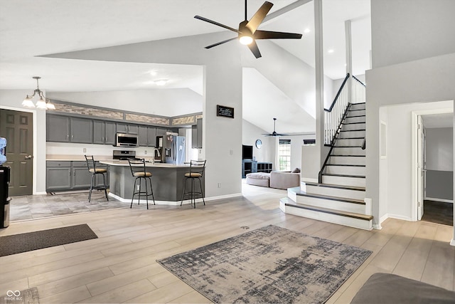 1264 Black Oak Dr, Greenwood, IN 46143 - living area with a ceiling fan, high vaulted ceiling, stairway, light wood-style flooring, and a chandelier
