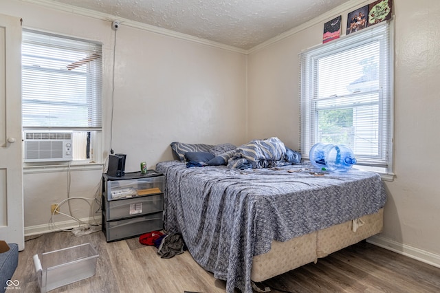 3065 N Colorado Ave, Indianapolis, IN 46218 - bedroom with wood finished floors, crown molding, a textured ceiling, cooling unit, and baseboards