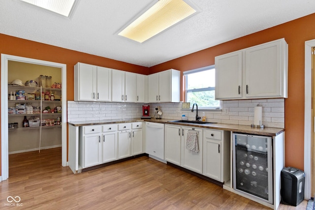 3362 Pavetto Ln, Indianapolis, IN 46203 - kitchen featuring beverage cooler, white dishwasher, light wood finished floors, and white cabinetry