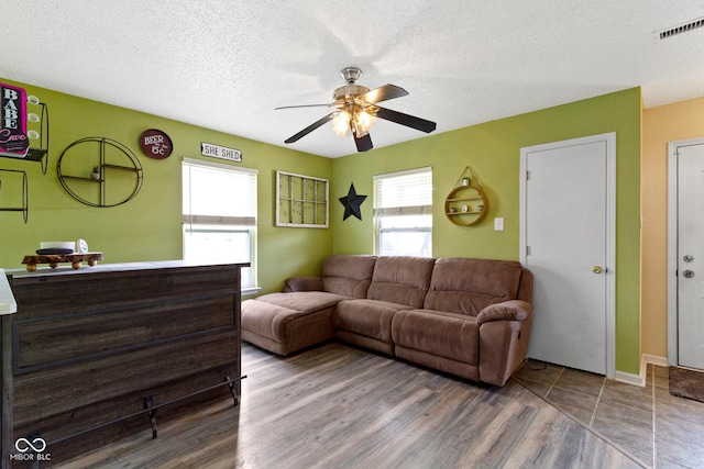 3362 Pavetto Ln, Indianapolis, IN 46203 - living area featuring a ceiling fan, healthy amount of natural light, wood finished floors, and a textured ceiling