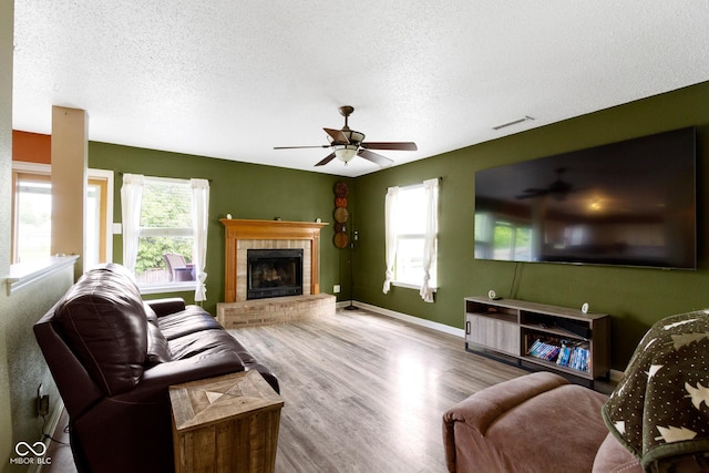 3362 Pavetto Ln, Indianapolis, IN 46203 - living room with a textured ceiling, ceiling fan, healthy amount of natural light, wood finished floors, and a fireplace