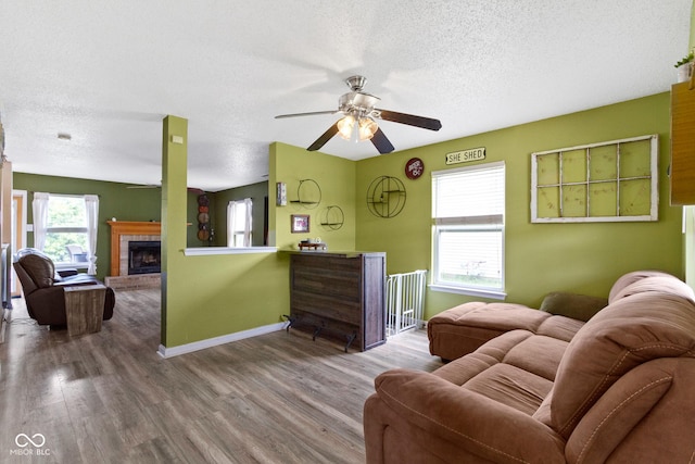 3362 Pavetto Ln, Indianapolis, IN 46203 - living area featuring a textured ceiling, ceiling fan, wood finished floors, and a fireplace