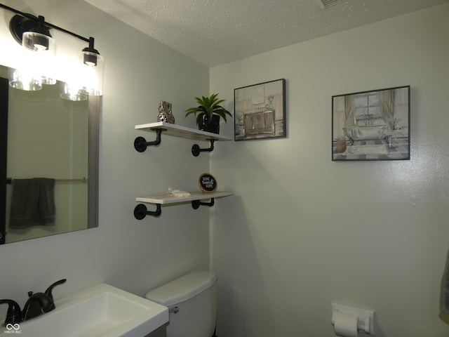 6714 Colleens Way, Indianapolis, IN 46221 - half bath with a sink, toilet, and a textured ceiling